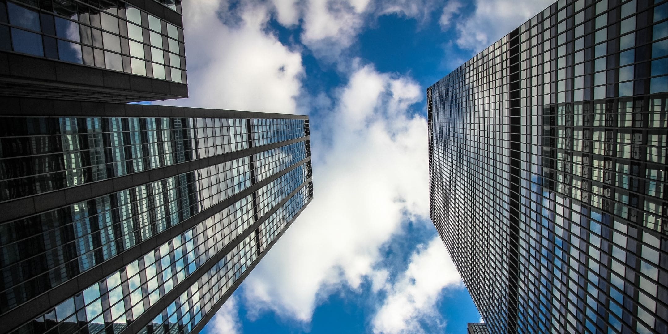 upward shot of clouds through highrise business district